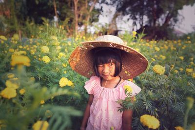 Full length of girl standing by flowering plants