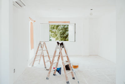 Ladders and painter tools on white room at construction site. painting walls. home improvement