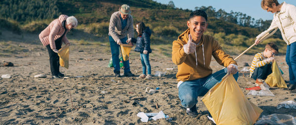 Family picking garbage while cleaning beach