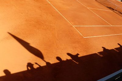 High angle view of people shadow on tennis field