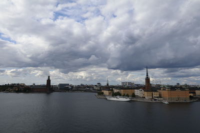 View of buildings in city against cloudy sky