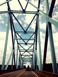 Vehicles on bridge against sky