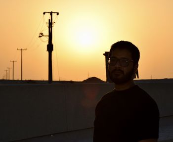 Portrait of man standing against sky during sunset 