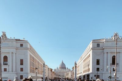 Buildings in city against clear blue sky