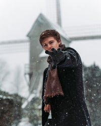 Portrait of man gesturing while standing in snow