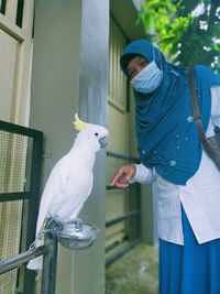 View of woman standing in front of a bird