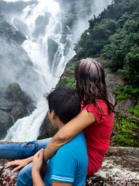 Rear view of mother and son against mountains at waterfall