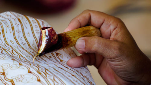 Close-up of hand holding bread on table