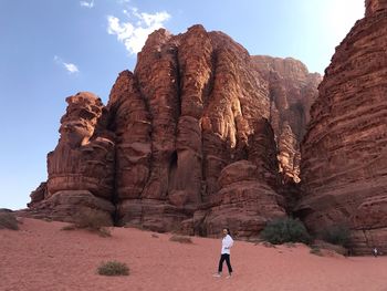 Woman standing at desert against rock formation 