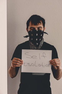 Portrait of young man standing against wall