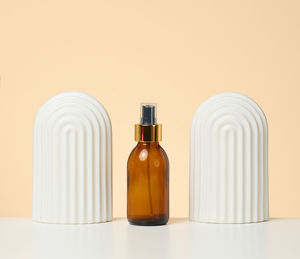 Brown glass bottle with spray on white background. cosmetics spa branding mockup