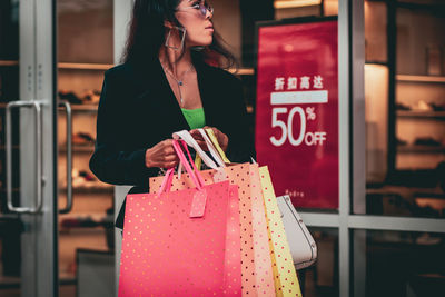 Midsection of woman standing by store