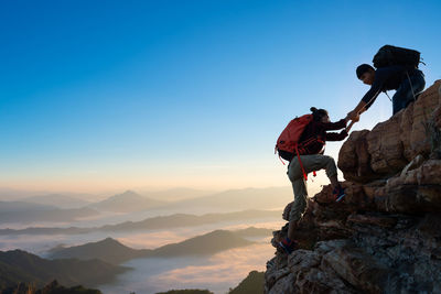 Asia couple hiking help each other on mountains view . teamwork