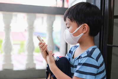 Portrait of boy holding mobile phone