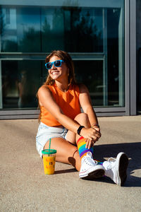Happy  teen girl in bright colorful top, rainbow socks and sunglasses . trendy teenager generation z 