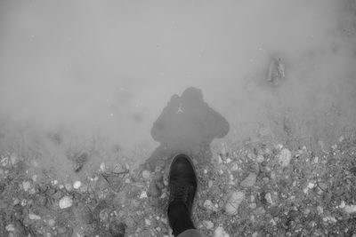 Low section of woman standing in water