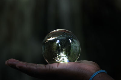 Close-up of hand holding crystal ball