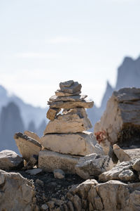 Stack of stones on rock against sky