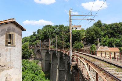 Railroad tracks by bridge against sky