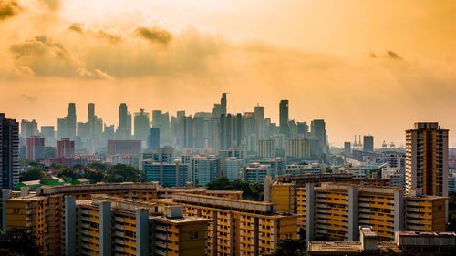 Modern buildings in city against sky during sunset