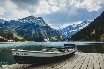 Scenic view of lake by mountains against sky