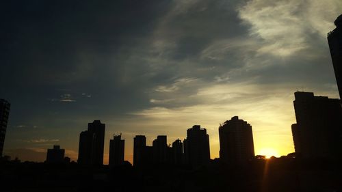 Silhouette buildings against sky during sunset