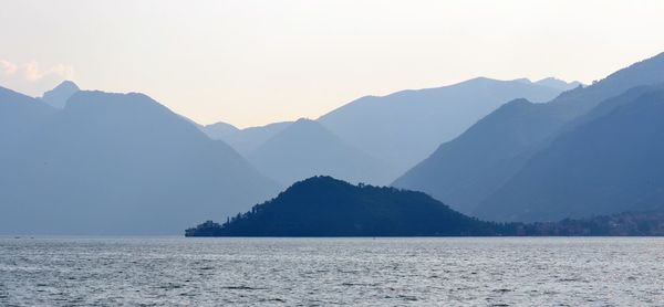 Scenic view of sea and mountains against clear sky