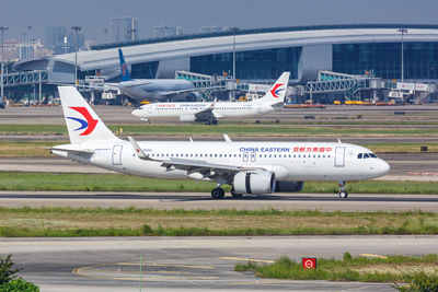 Airplane on airport runway against sky