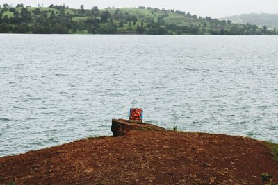 Man sitting on shore against sea