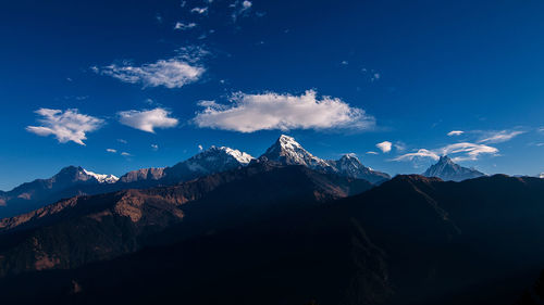 Scenic view of snowcapped mountains against blue sky