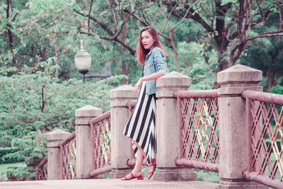 Woman sitting on bench in park