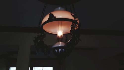 Low angle view of illuminated pendant light hanging from ceiling