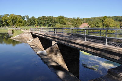 Bridge over river against clear blue sky