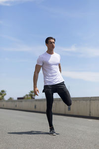 Confident young man exercising during sunny day