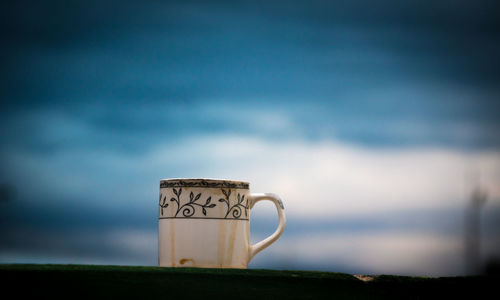Close-up of coffee cup against sky