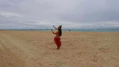 Scenic view of beach against cloudy sky