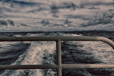 Railing by sea against sky