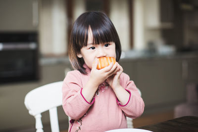 Portrait of a girl eating food at home