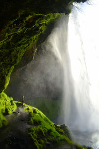 Full length of woman looking at waterfall