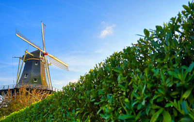 Low angle view of traditional windmill against sky