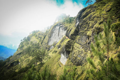 Low angle view of rocks on mountain against sky