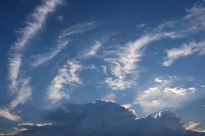 Low angle view of sunlight streaming through clouds