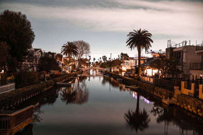 Reflection of palm trees and buildings in lake