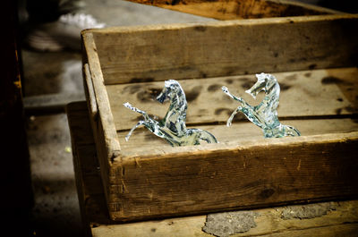 High angle view of handmade glass horses in murano on wood