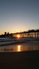 Pier on sea at sunset
