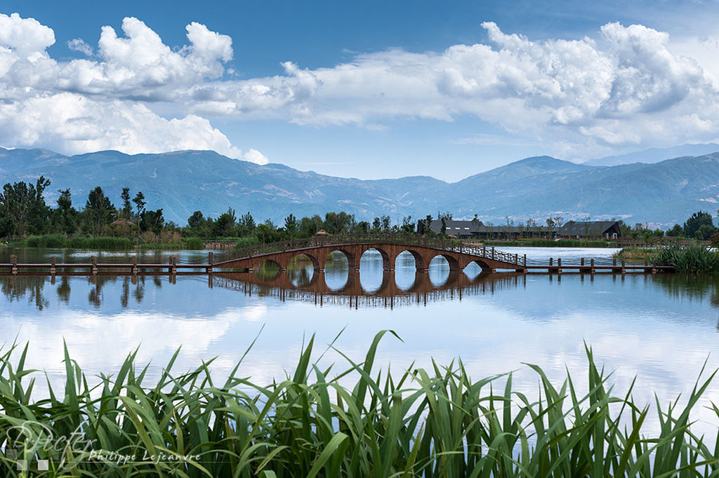 water, mountain, lake, sky, tranquil scene, tranquility, mountain range, scenics, reflection, beauty in nature, nature, plant, river, cloud, cloud - sky, grass, idyllic, landscape, tree, outdoors