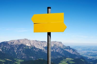 Direction sign with space for text in front of a mountain