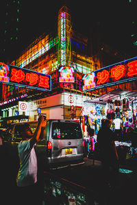 People on illuminated street at night