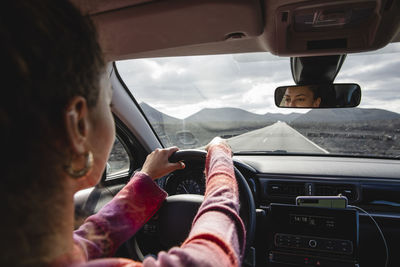 Woman driving car on road trip