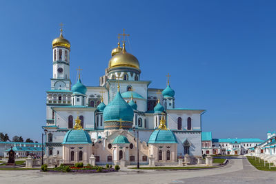 View of buildings in city against clear blue sky